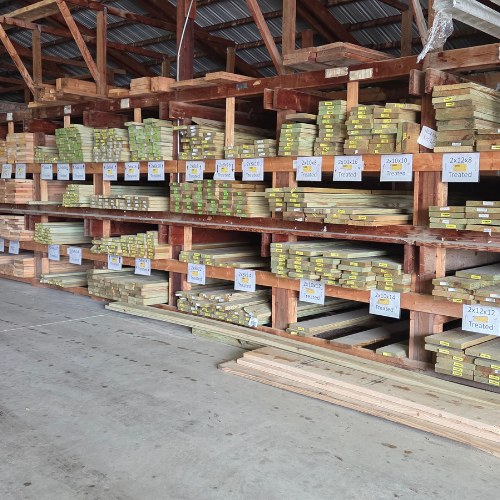 Stacks of lumber organized on wooden shelves in a warehouse, with labels indicating different sizes and types, creating a neat, orderly atmosphere.