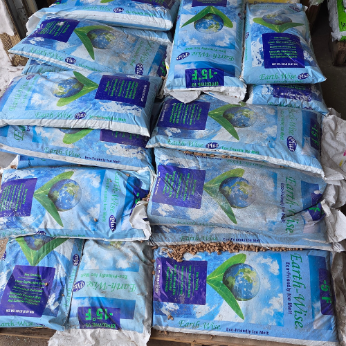 Bags of ice melt are stacked in two rows. The packaging is blue with images of a globe and green checkmarks, labeled 