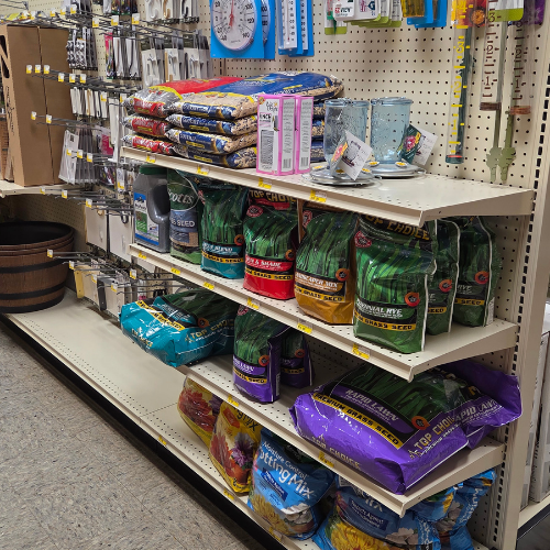 Store aisle with shelves stocked with various brands of bird seed and pet food, colorful packaging. A serene, organized shopping environment.