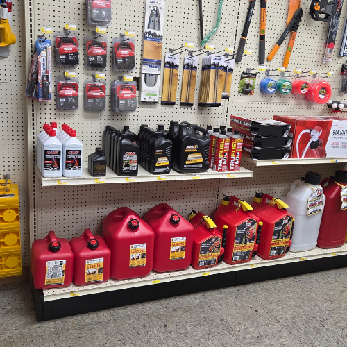 Store aisle with shelves displaying automotive products. Red fuel canisters, motor oil bottles, and various tools are neatly arranged, conveying a practical tone.